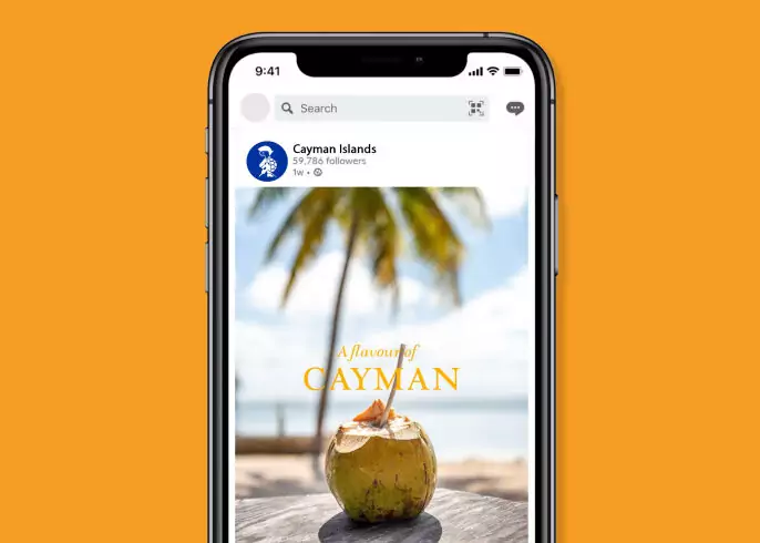 Smartphone displaying a Cayman Islands travel promotion with a coconut drink on a tropical beach, representing digital customer experience campaigns.