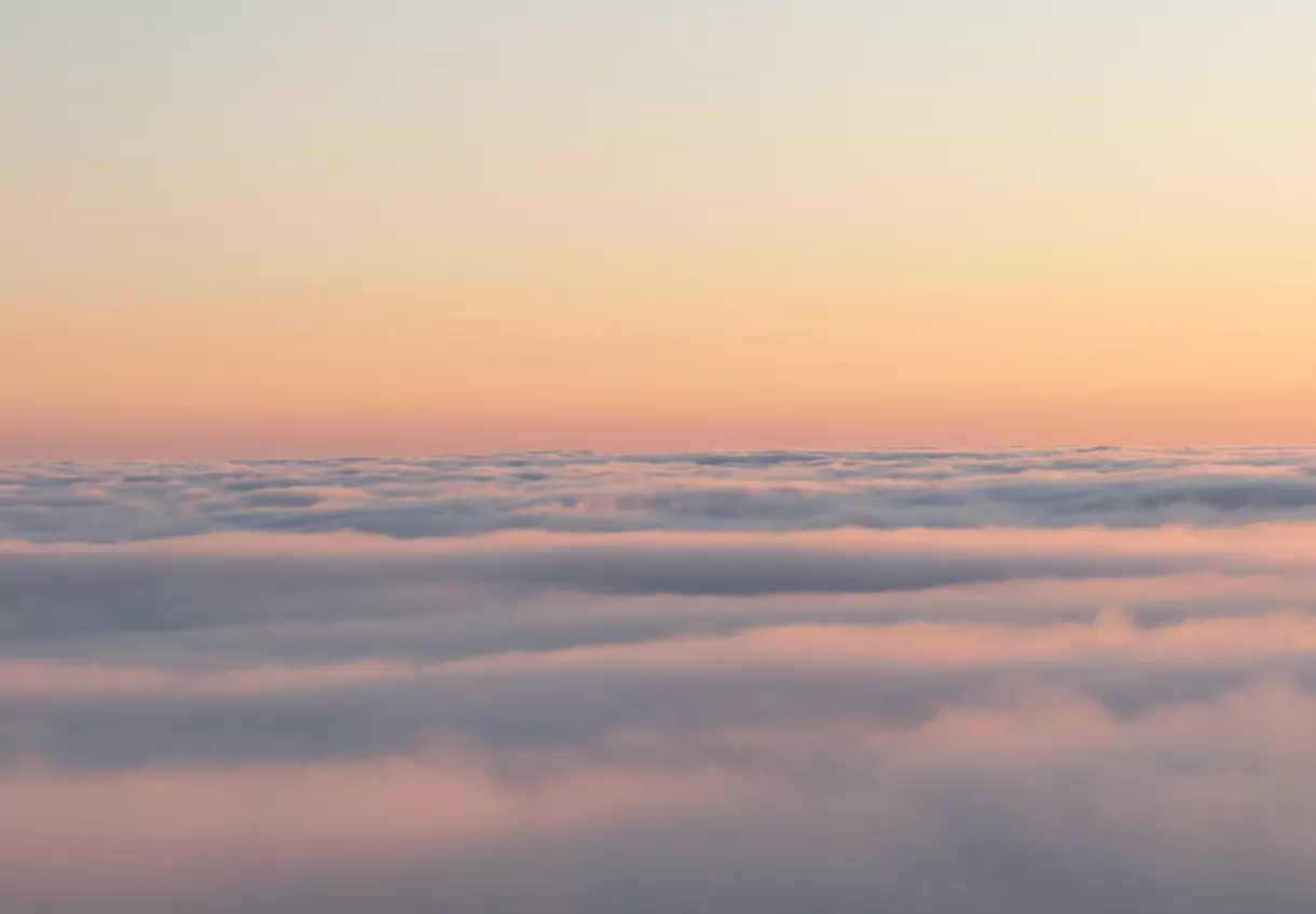 Sunrise above cloud layer representing clean energy, sustainability and low-carbon innovation